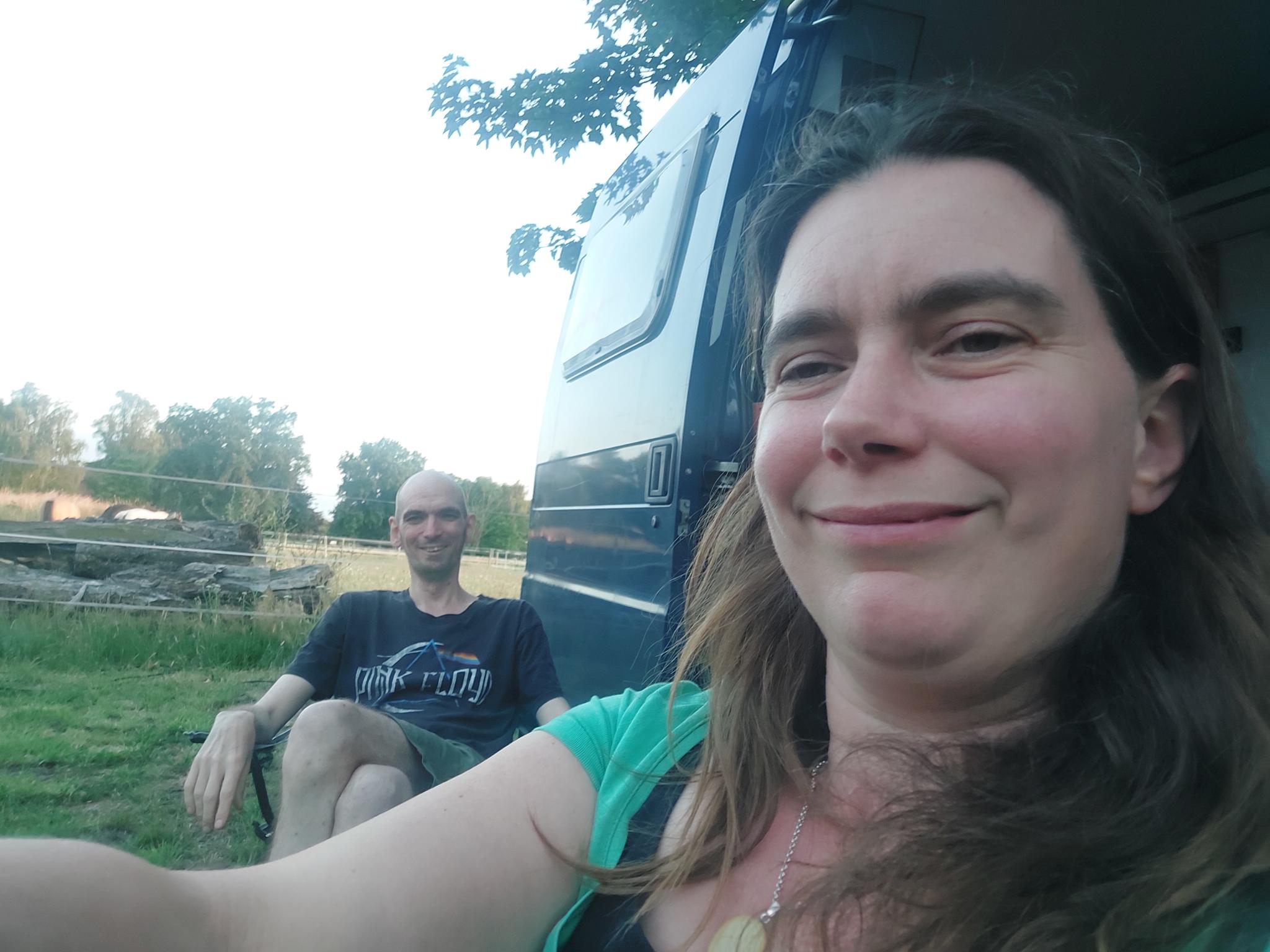 Je ziet Suzanne en ik zitten in campingstoeltjes naast de bus